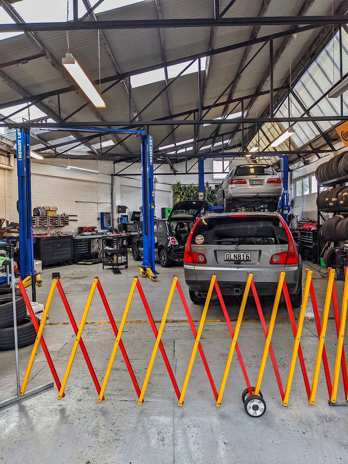 Workshop interior with vehicles on hoists being serviced
